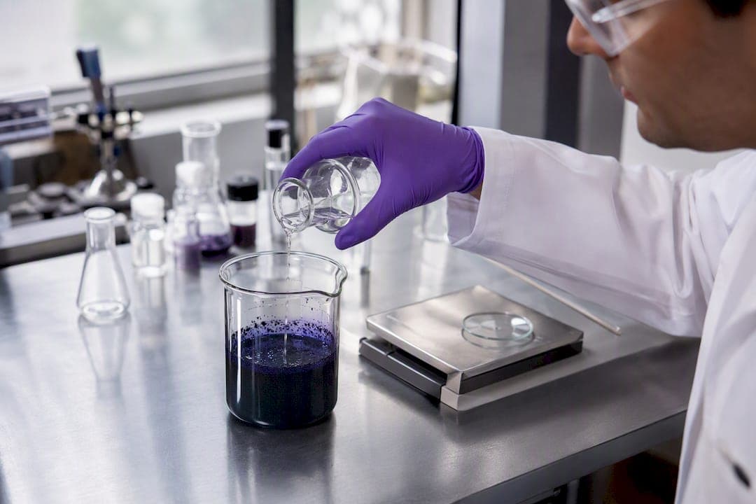 Technician adjusting pigment dispersion in lab beaker