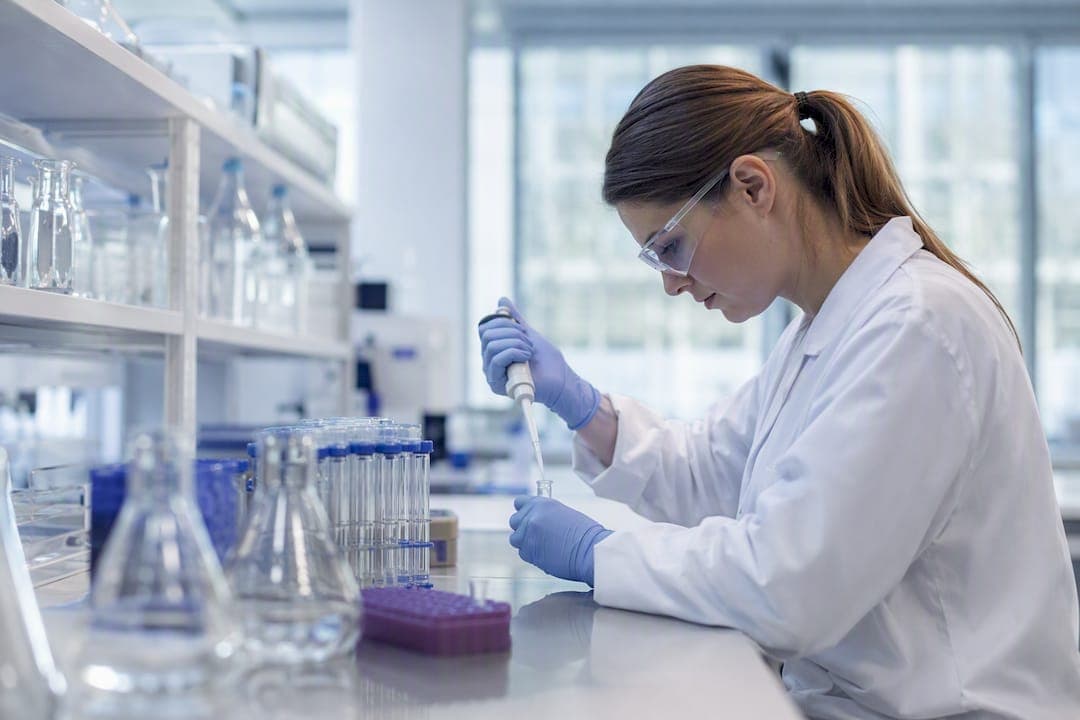 Technician pipetting sample in chemical lab