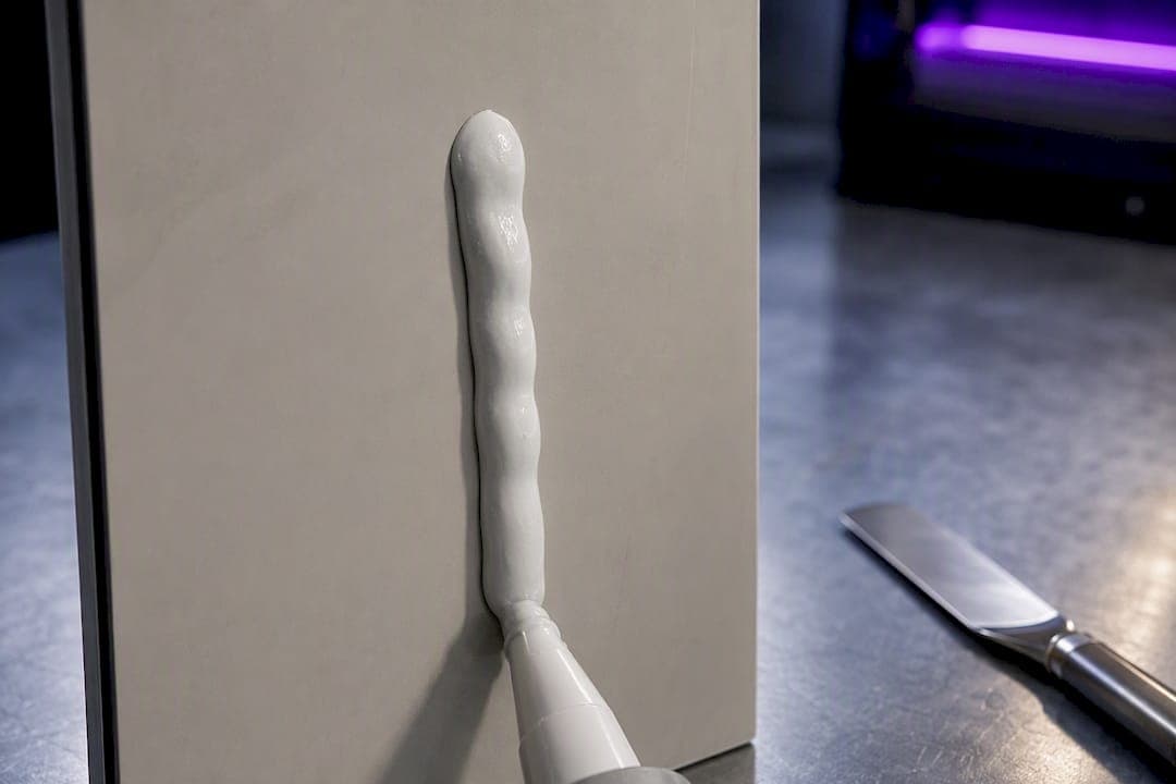 Adhesive bead holding shape on vertical panel